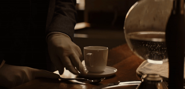Professor T measures a level spoon of coffee and polishes his shoes.
